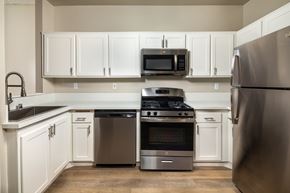 Santa Clarita apartment for rent - A kitchen with a stainless steel refrigerator, oven, and microwave.