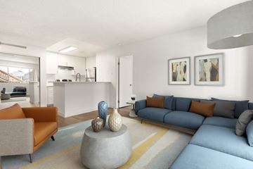 El Cajon apartment for rent - A living room with a grey couch and a grey coffee table with a blue couch and orange pillows.