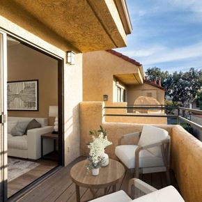 Grand Terrace apartment for rent - A balcony with a table and chairs overlooking a pool.