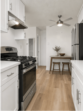 El Cajon apartment for rent - A modern kitchen with a black stove top oven and white cabinets.