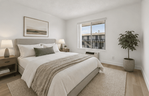 El Cajon apartment for rent - A bedroom with a large bed and a potted plant.