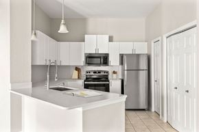 Jacksonville apartment for rent - A modern kitchen with white cabinets and appliances.