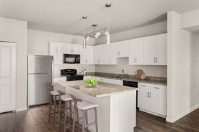 Phoenix apartment for rent - A kitchen with white cabinets and a granite countertop.