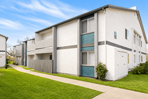Ramona apartment for rent - A white apartment building with a green door and a grey fence.
