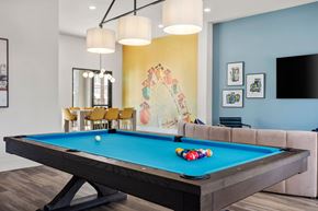 Surprise apartment for rent - A pool table with a blue cloth and a white ball in the middle.