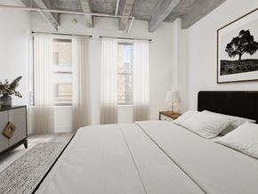 Los Angeles apartment for rent - A bedroom with a large bed, a nightstand with a lamp, and a framed picture of a tree on the wall.