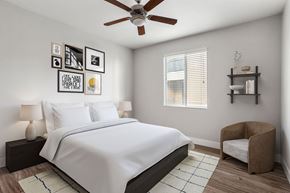 Surprise apartment for rent - A bedroom with a bed, chair, and pictures on the wall.