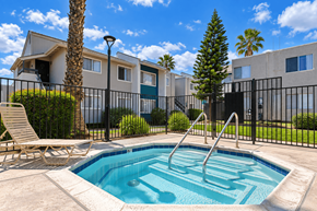Ramona apartment for rent - A pool surrounded by a black fence with a chair and a tree.