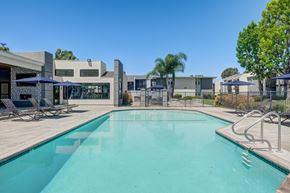 Lakewood apartment for rent - A swimming pool surrounded by a fence and chairs.