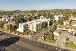 Escondido apartment for rent - A street view of a residential area with apartment buildings and parked cars.
