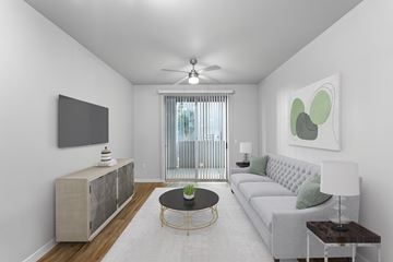 Phoenix apartment for rent - A living room with a grey sofa, a black coffee table, and a television on the wall.