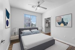 Phoenix apartment for rent - A bedroom with a bed, a ceiling fan, and two wall art pieces.