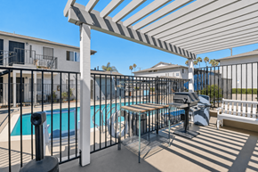 Ramona apartment for rent - A pool area with a white pergola and black fence.