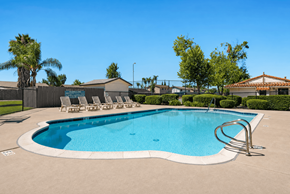 Ramona apartment for rent - A large outdoor swimming pool with a metal ladder.