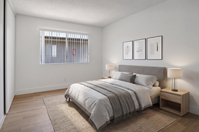 El Cajon apartment for rent - A bedroom with a large bed and a window with bars.