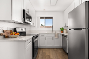 Ramona apartment for rent - A kitchen with white cabinets and a stainless steel refrigerator.