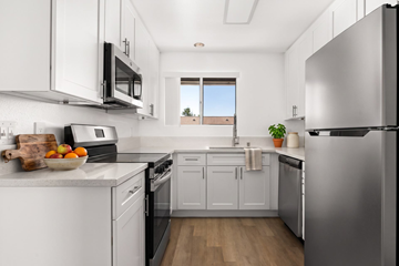 Ramona apartment for rent - A kitchen with white cabinets and a stainless steel refrigerator.