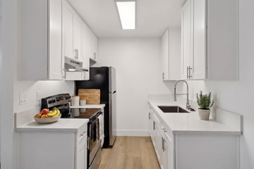El Cajon apartment for rent - A kitchen with white cabinets and a black refrigerator.