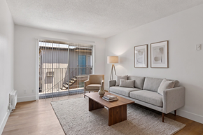El Cajon apartment for rent - A living room with a grey couch, a brown coffee table, and a lamp.