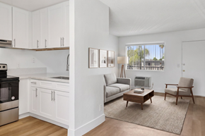 El Cajon apartment for rent - A modern kitchen with white cabinets and a grey sofa.