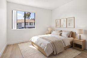 El Cajon apartment for rent - A bedroom with a large bed and a window overlooking a building.
