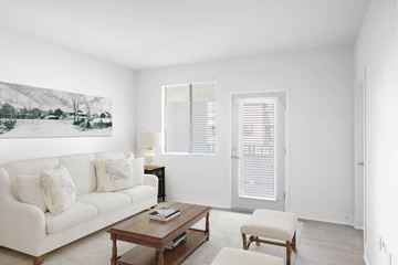 Gilbert apartment for rent - A living room with a white couch, a coffee table, and a painting on the wall.