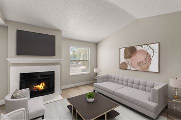 Mesa apartment for rent - A living room with a fireplace, a grey sofa, a coffee table, and a painting on the wall.