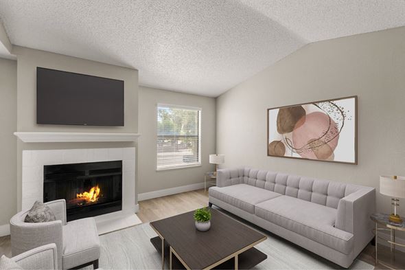 Mesa apartment for rent - A living room with a fireplace, a grey sofa, a coffee table, and a painting on the wall.