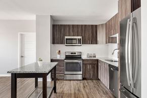 Gilbert apartment for rent - A modern kitchen with a granite table and stainless steel appliances.