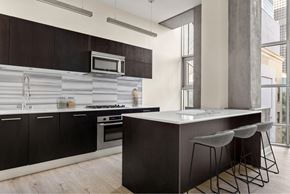 Los Angeles apartment for rent - A modern kitchen with dark wood cabinets and a white countertop.