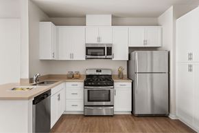 Los Angeles apartment for rent - A modern kitchen with white cabinets and stainless steel appliances.