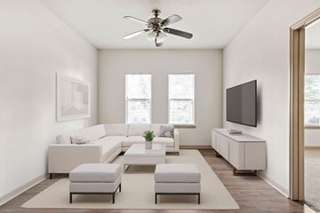 Jacksonville apartment for rent - A living room with a white sofa set, a television, and a ceiling fan.
