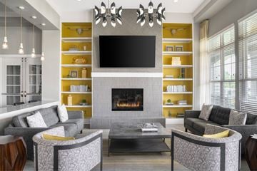 Charlotte apartment for rent - A modern living room with a grey fireplace and a television mounted above it.