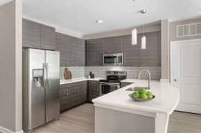 Charlotte apartment for rent - A modern kitchen with a stainless steel refrigerator and a white countertop.