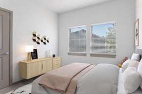 Oregon City apartment for rent - A bedroom with a bed, a nightstand with a lamp, and a wall art.