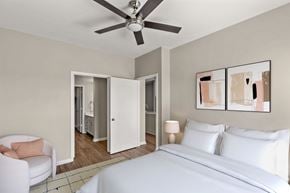 Frisco apartment for rent - A bedroom with a white bed and a ceiling fan.