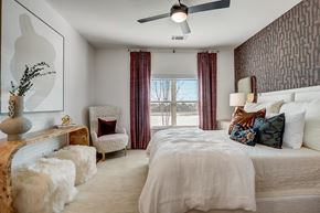 Haslet apartment for rent - A bedroom with a large bed and a chair with a plant on a table.