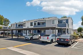 Spring Valley apartment for rent - A parking lot with three cars parked in front of a building.