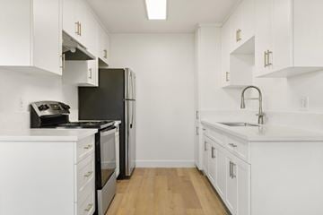 El Cajon apartment for rent - A kitchen with white cabinets and a black refrigerator.