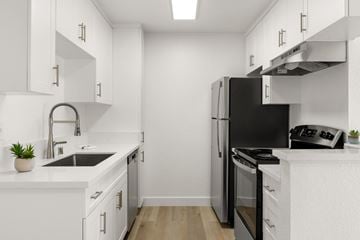 San Ysidro apartment for rent - A modern kitchen with white cabinets and black appliances.