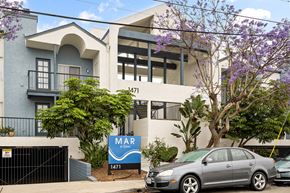 Imperial Beach apartment for rent - A grey car is parked in front of a building with a sign that says