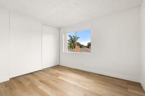 San Ysidro apartment for rent - A room with a window showing a view of a building and trees outside.