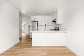 San Ysidro apartment for rent - A kitchen with white cabinets and a wooden floor.