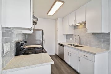 San Diego apartment for rent - A kitchen with white cabinets and a tiled backsplash.