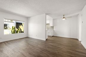 San Diego apartment for rent - A spacious room with wooden flooring and a ceiling fan.