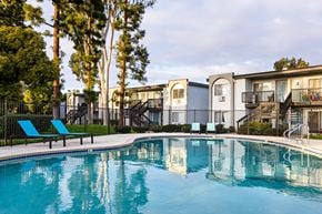 Escondido apartment for rent - A swimming pool in front of apartment buildings with trees in the background.