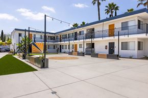 San Diego apartment for rent - A modern building with a white and orange facade and a balcony with black railings.