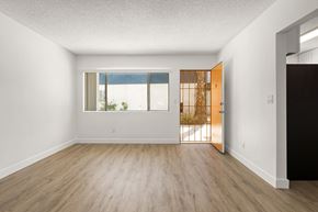 San Diego apartment for rent - A room with a wooden floor and a door leading to a balcony.