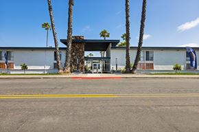 San Diego apartment for rent - A building with a palm tree in front of it.