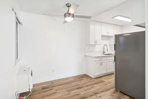 El Cajon apartment for rent - A kitchen with a refrigerator, sink, and cabinets.